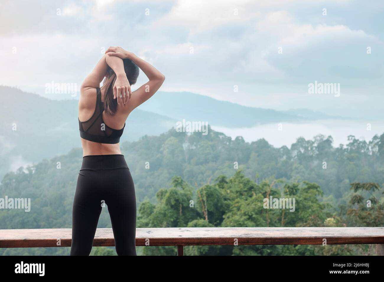 Atleta donna esercizio al mattino, giovane donna fitness stretching muscolo contro vista montagna, riscaldamento pronto per correre o jogging. Allenamento, wellbei Foto Stock