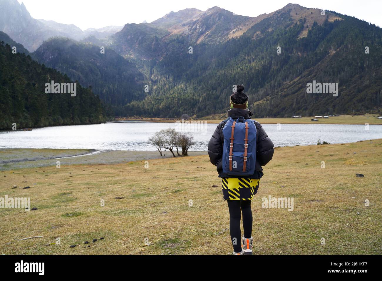 vista posteriore di una donna asiatica zaino in spalla a piedi verso la montagna e il lago Foto Stock