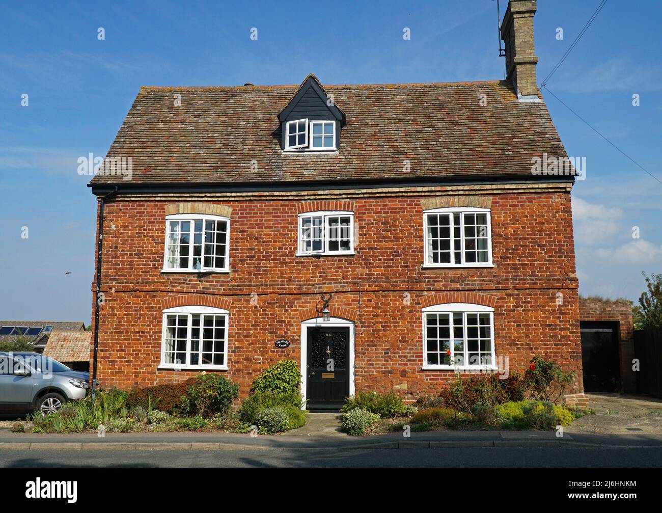 Bella vecchia casa in mattoni rossi fronte doppia in villaggio impostazione. Foto Stock