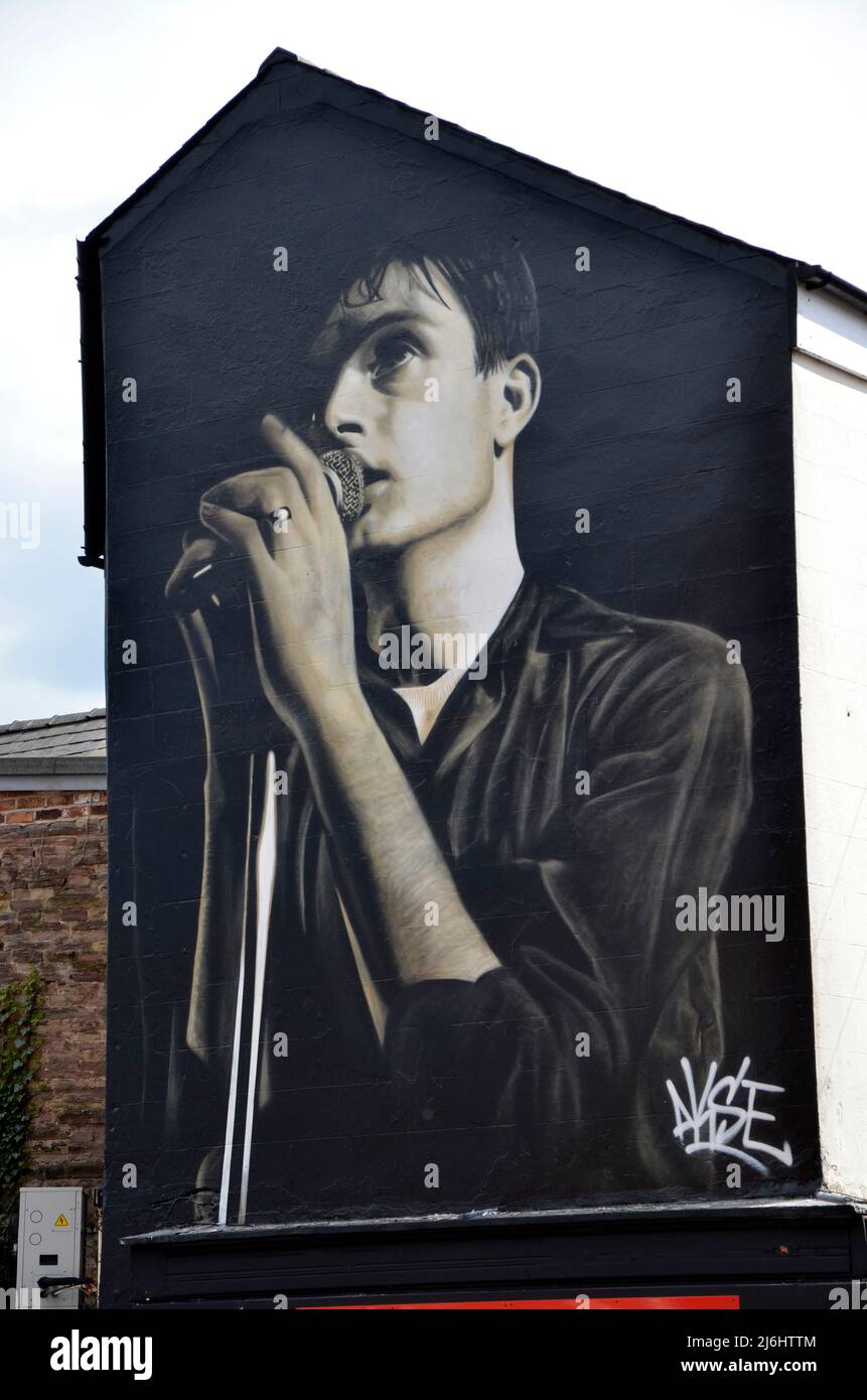 Un murale a Macclesfield dell'artista di strada Akse in omaggio a Ian Curtis, cantante principale della divisione di gioia, che è stato sopportato nella città di Cheshire. Foto Stock