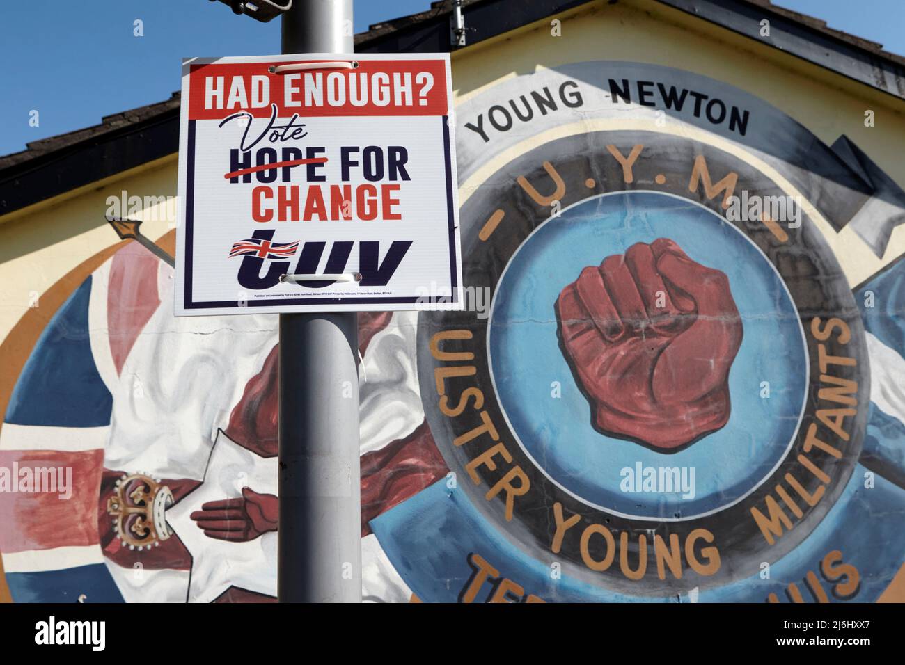 TUV (Traditional Unionist Voice) poster elettorale accanto ai murales paramilitari Loyalist su 'Freedom Corner' Lower Newtownards Road, East Belfast, North Foto Stock
