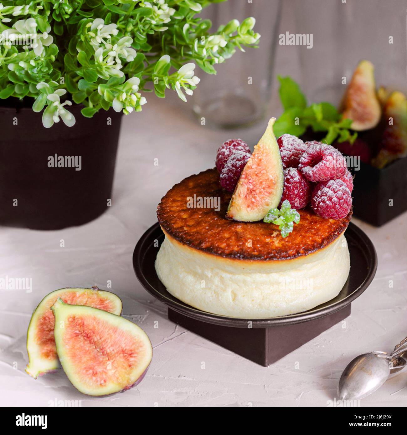 Cremosa di New York style Cheesecake con berry topping. Esempio di elegante foodstyling con frutti, fig, lampone e menta. Foto Stock