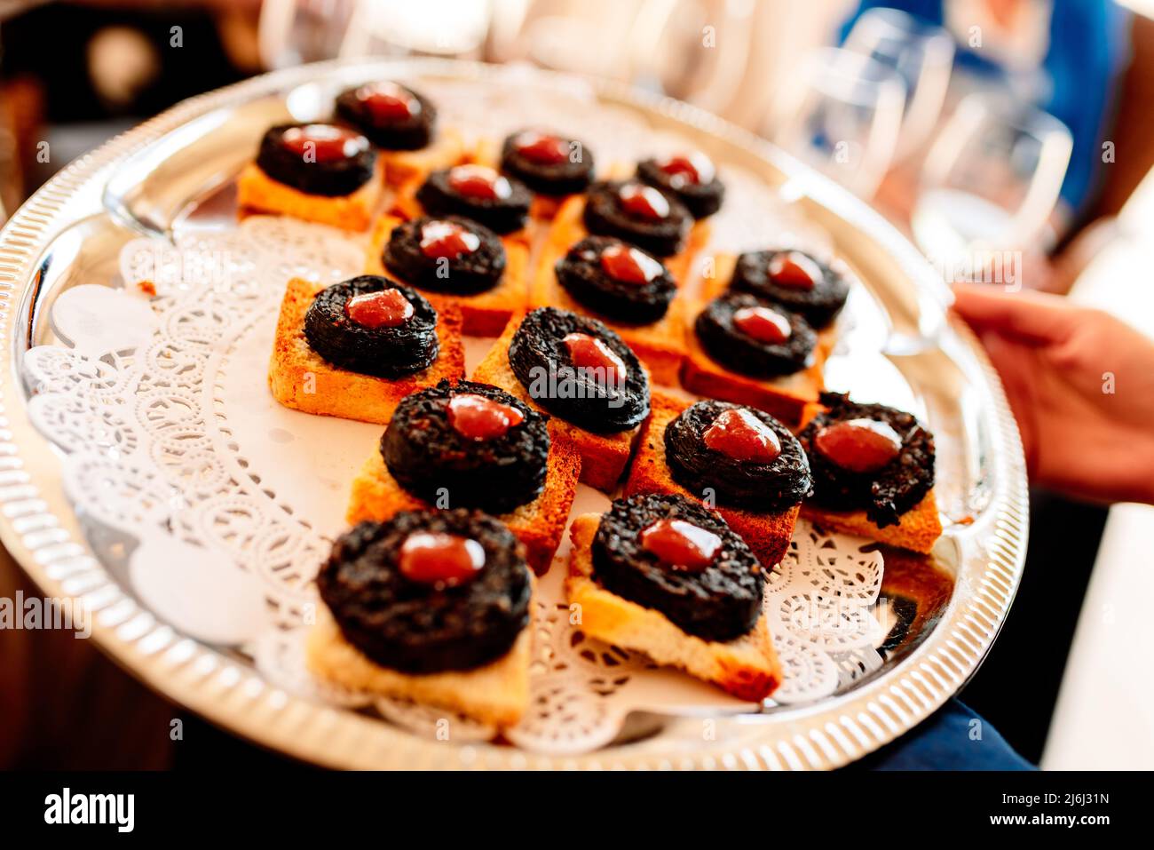 I camerieri offrono un vassoio con antipasti agli ospiti in occasione di una festa. Foto Stock