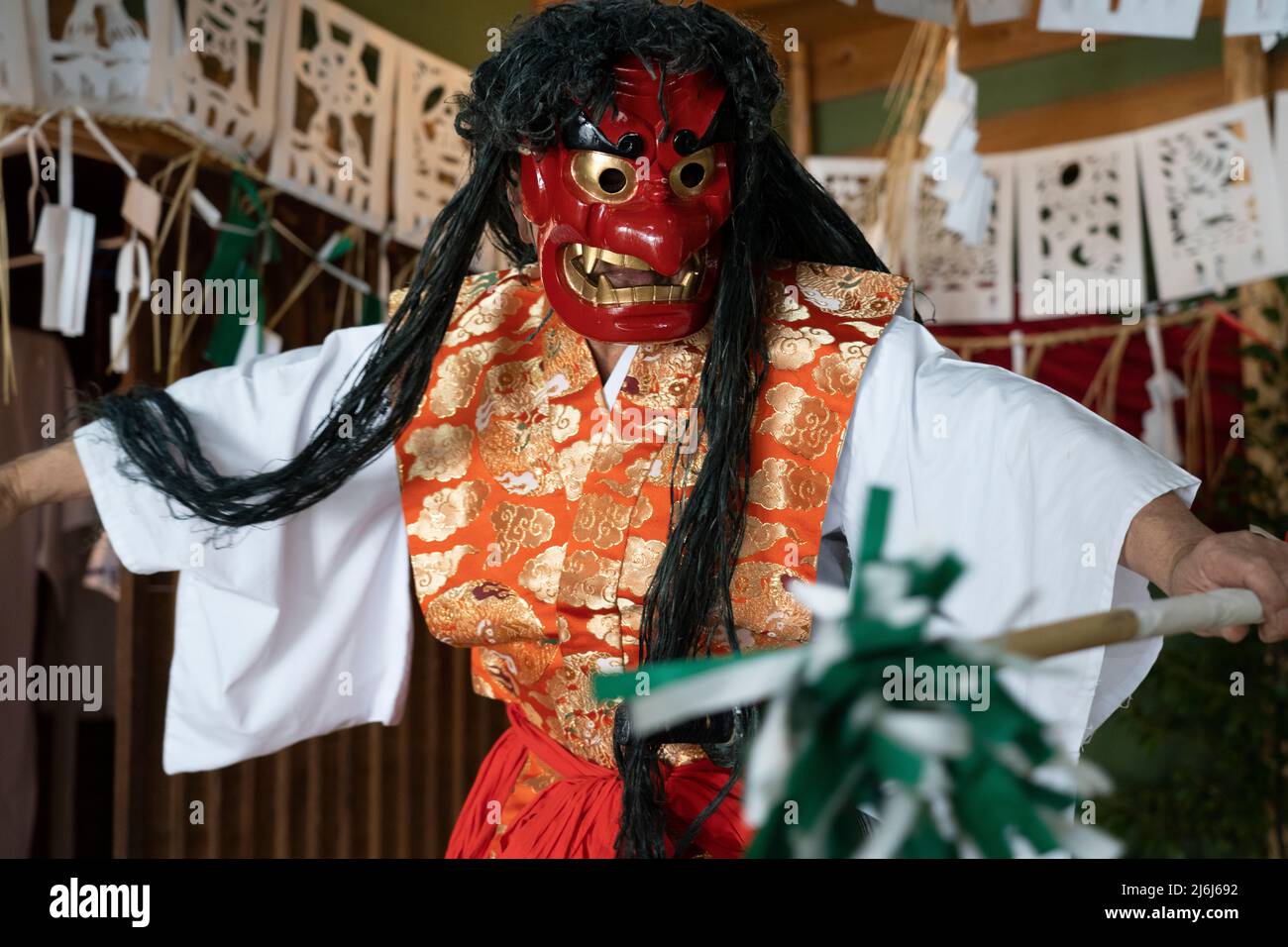 Fujisaki-san, un maestro della rappresentazione rituale di Kagura lo Shinto che racconta le stoires degli dei. Indossare la maschera rossa della danza Totori. Takachiho, K. Foto Stock