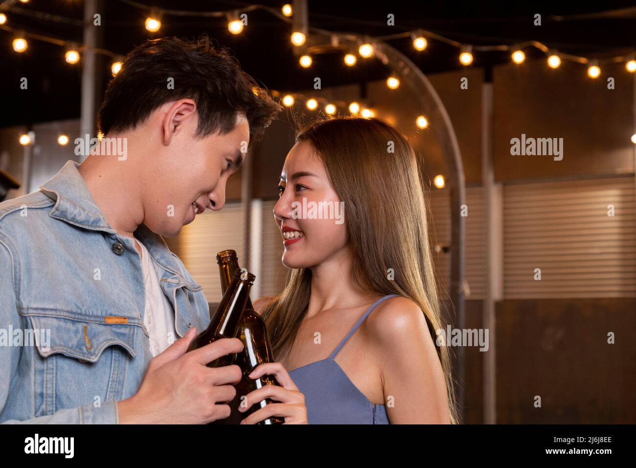 felice asiatico adolescente coppia uomo e donna in amore bere birra alcol e tostatura bottiglia in festa. giovane coppia felice amore e romantico Foto Stock