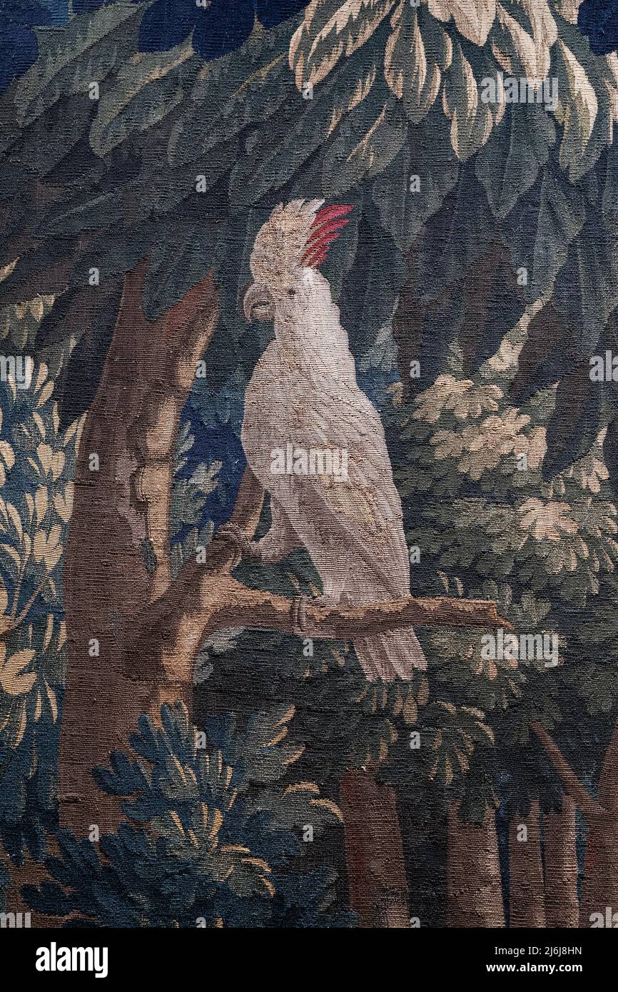 Un raccolto vicino generico di un arazzo antico che raffigura un uccello di pappagallo di cockatoo e gli alberi Foto Stock