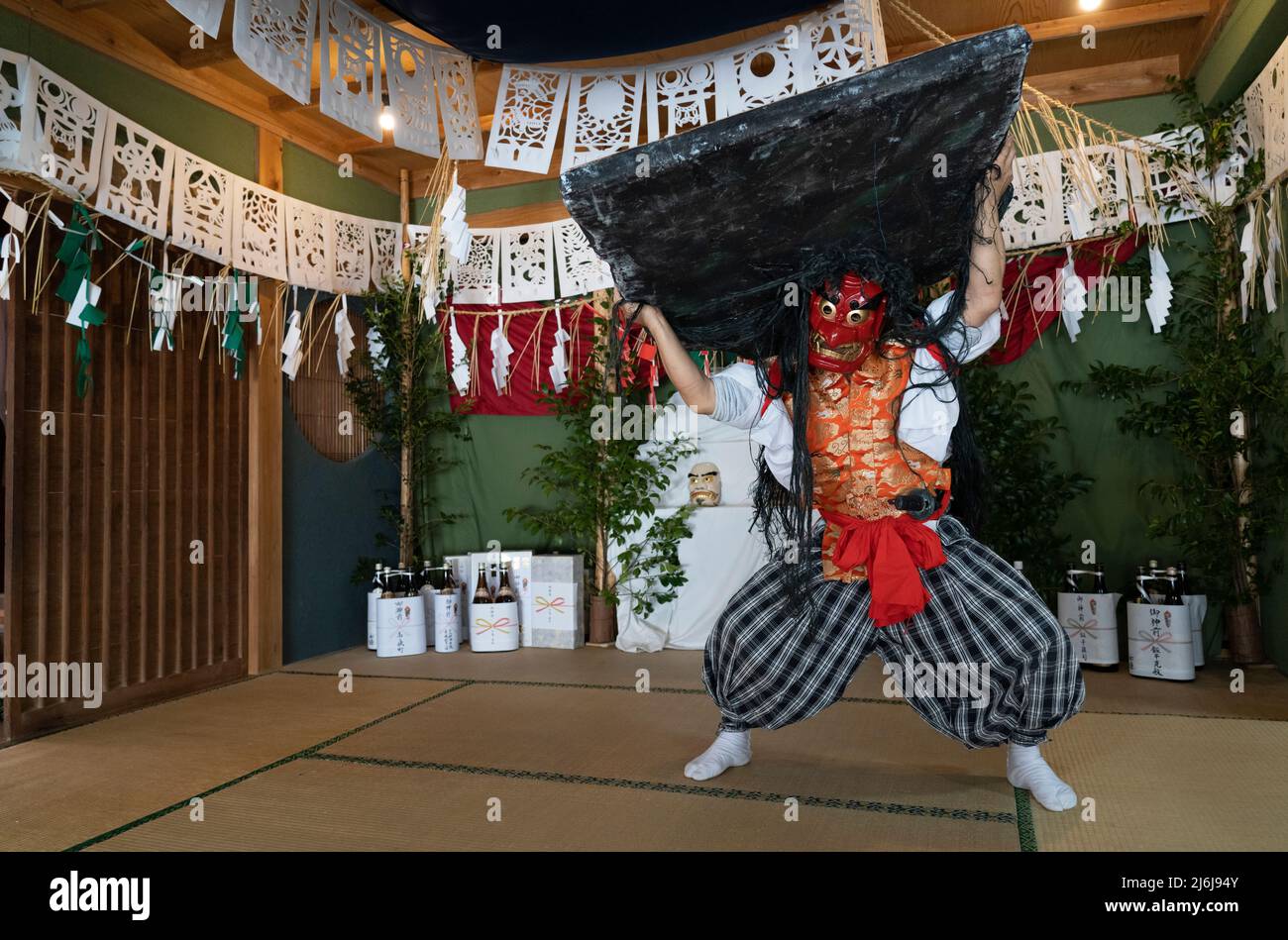 Fujisaki-san, un maestro della rappresentazione rituale di Kagura lo Shinto che racconta le stoires degli dei. Indossare la maschera rossa della danza Totori. Takachiho, K. Foto Stock