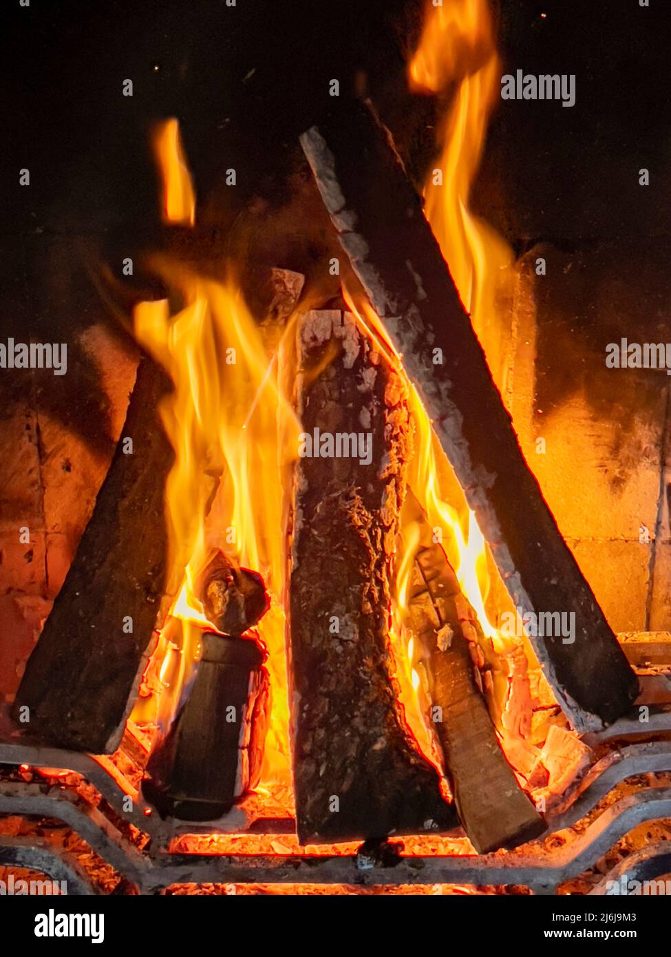 Bella fiamme ruggenti fuoco di legno che brucia nel camino. Una legna da ardere brucia mantenere caldo. Moderno camino come mobili, decorazione casa. Romantico Foto Stock