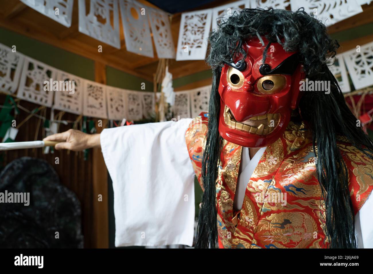 Fujisaki-san, un maestro della rappresentazione rituale di Kagura lo Shinto che racconta le stoires degli dei. Indossare la maschera rossa della danza Totori. Takachiho, K. Foto Stock