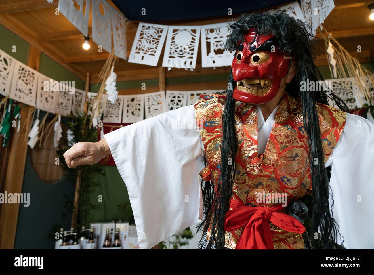 Fujisaki-san, un maestro della rappresentazione rituale di Kagura lo Shinto che racconta le stoires degli dei. Indossare la maschera rossa della danza Totori. Takachiho, K. Foto Stock