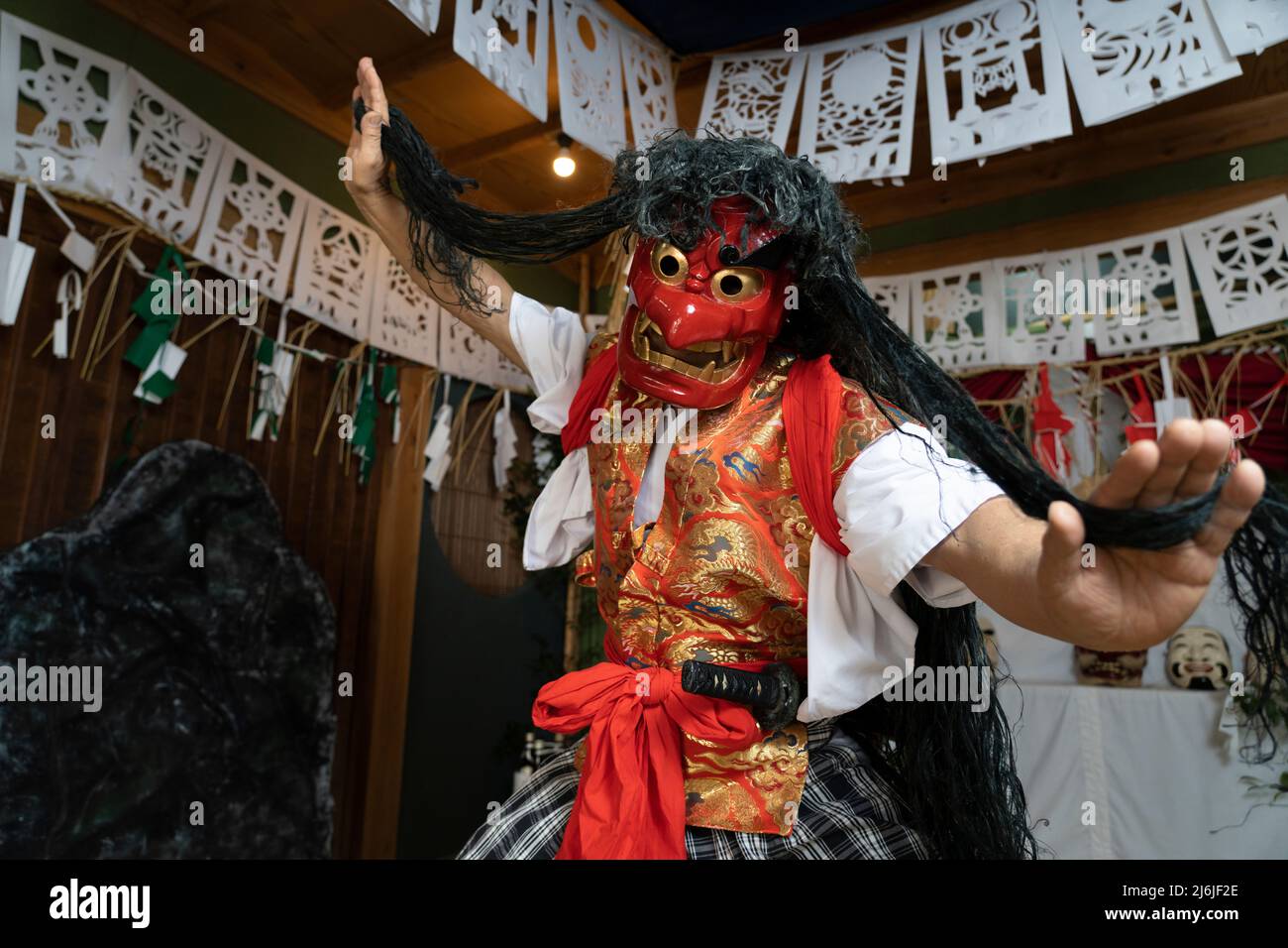 Fujisaki-san, un maestro della rappresentazione rituale di Kagura lo Shinto che racconta le stoires degli dei. Indossare la maschera rossa della danza Totori. Takachiho, K. Foto Stock