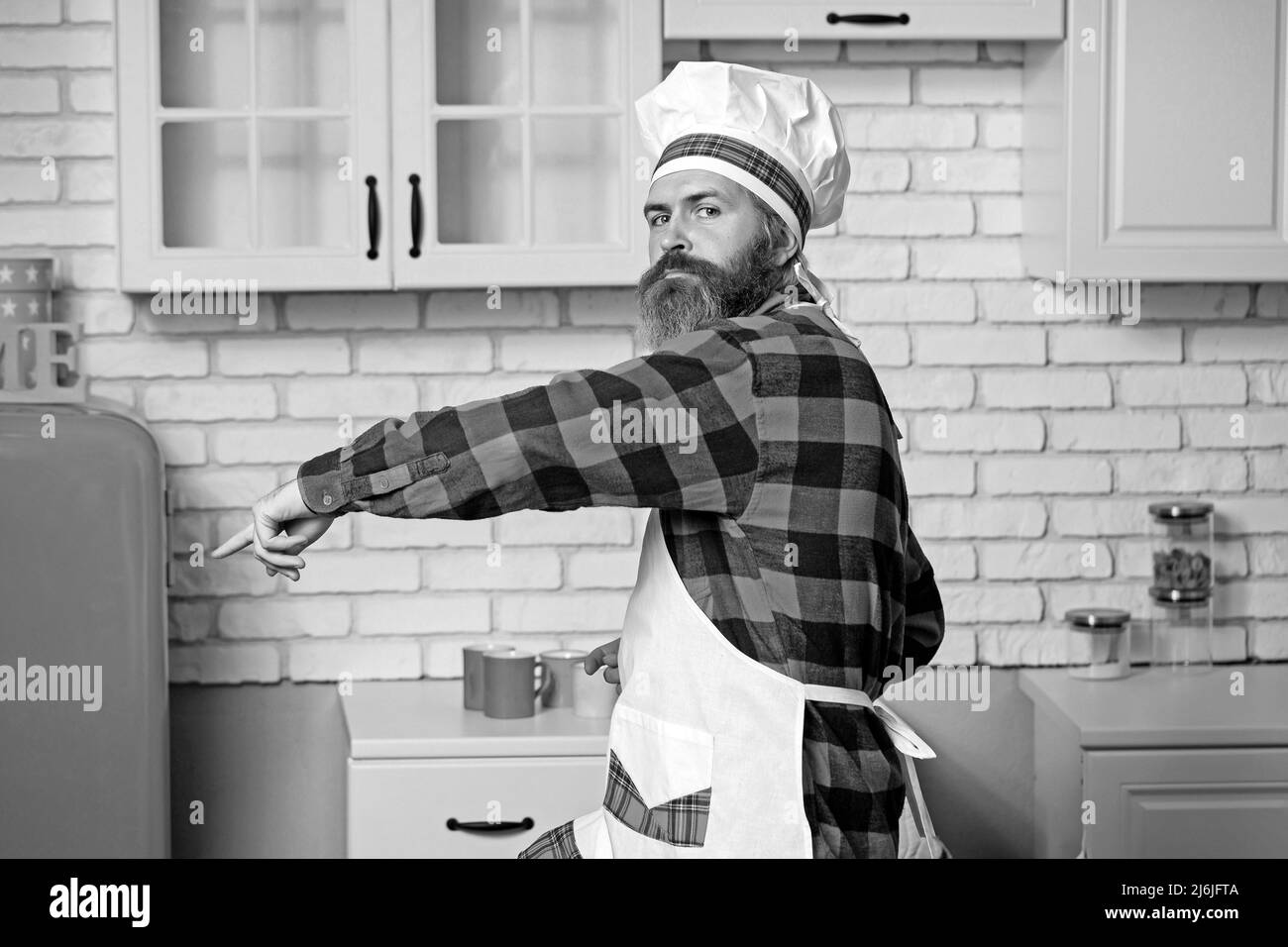 Chef, cucina che prepara gustosi piatti deliziosi. Chef maschile fiducioso in uniforme bianca Foto Stock