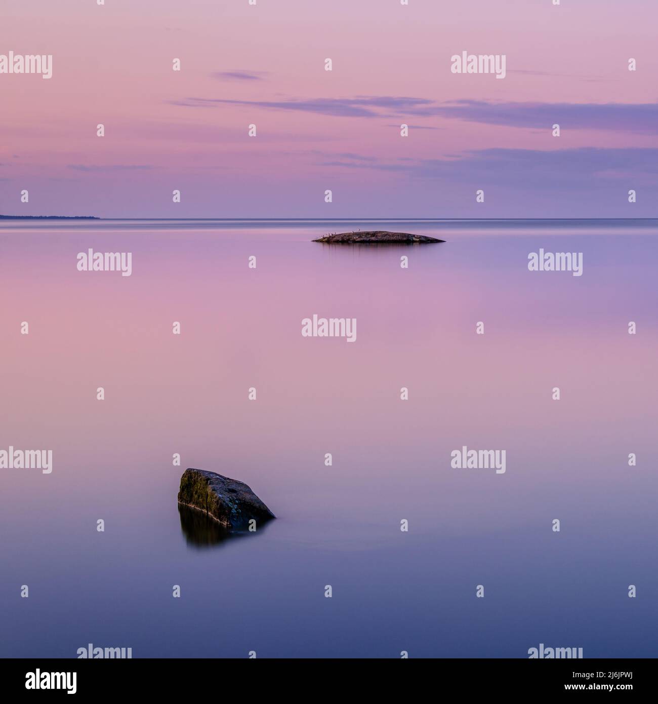 Pietre giacenti in acqua ferma al tramonto Foto Stock