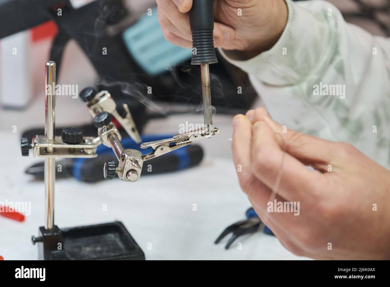 Il tecnico può saldare un cavo a coccodrillo. Foto Stock
