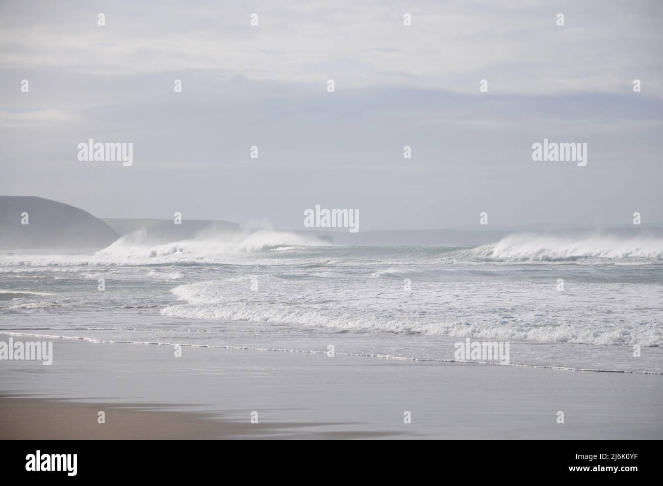 Un forte vento offshore e un forte rigonfiamento si combinano per creare un surf drammatico in inverno sulla costa nord della Cornovaglia Foto Stock