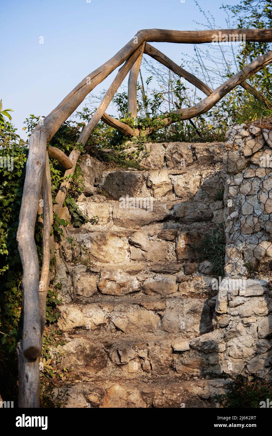 Vecchie scale di pietra soprarse da piante. Primo piano dell'antica scalinata in pietra. Foto Stock