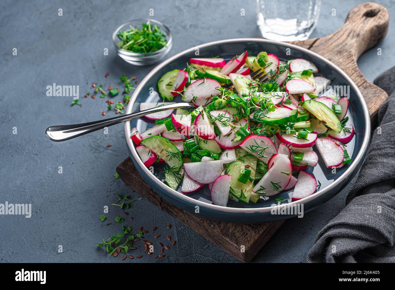 Insalata di verdure fresche con ravanelli ed erbe fresche su sfondo di grafite. Foto Stock
