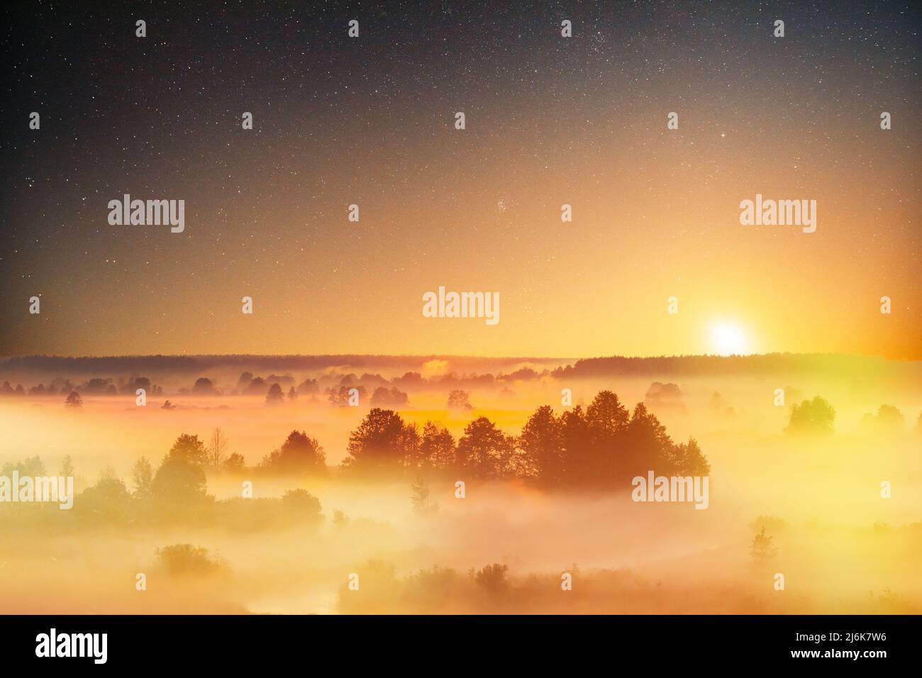Stelle stupende cielo stellato sopra Misty nebbia Paesaggio Scenico Vista del cielo del mattino con il sole in ascesa sopra la foresta. Notte cielo stellato cielo stellato incandescente Stelle Foto Stock