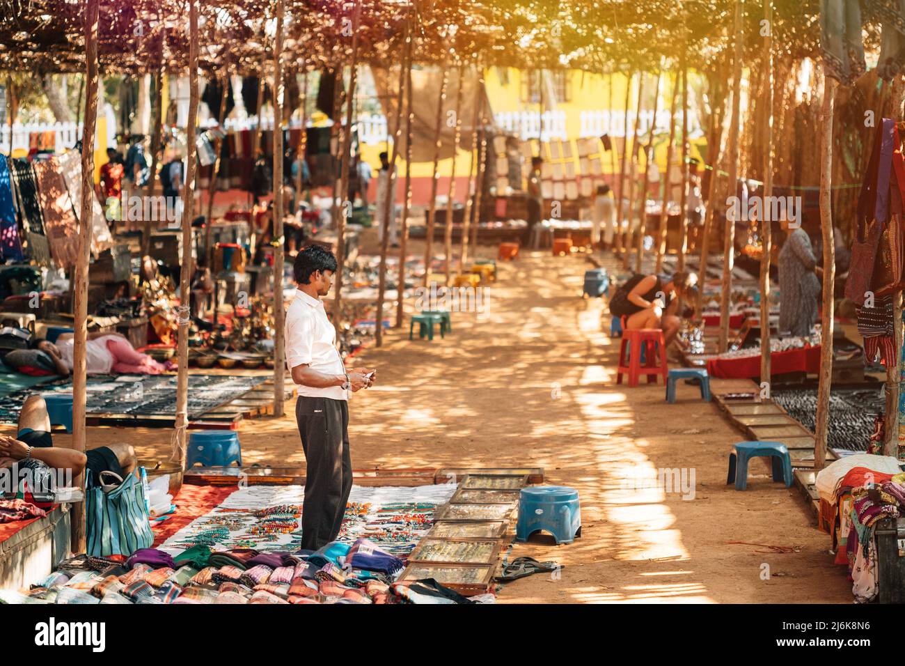 Anjuna, Goa, India - 19 febbraio 2020: Man Venditore vende souvenir indiani nel mercato di Anjuna Foto Stock