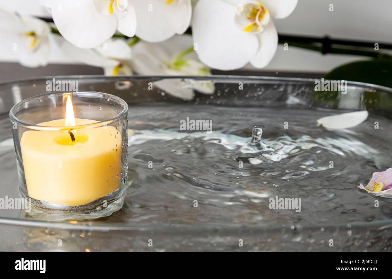 Foto di una candela con pioggia, gocce d'acqua che estinguono il fuoco, spruzzi d'acqua Foto Stock