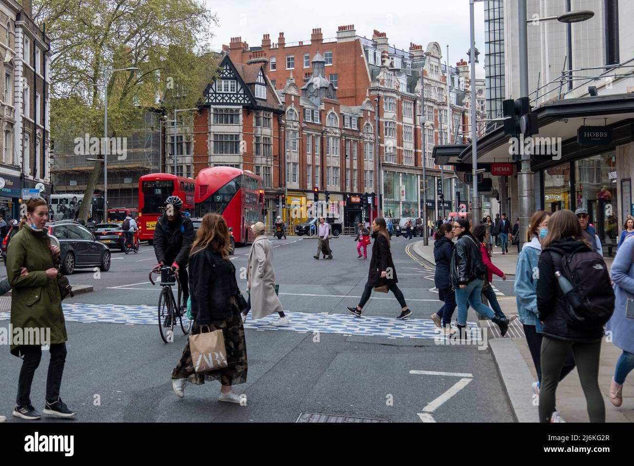 Londra, 2022 aprile: Scena di strada trafficata con gli amanti dello shopping a piedi su Kensington High Street Foto Stock