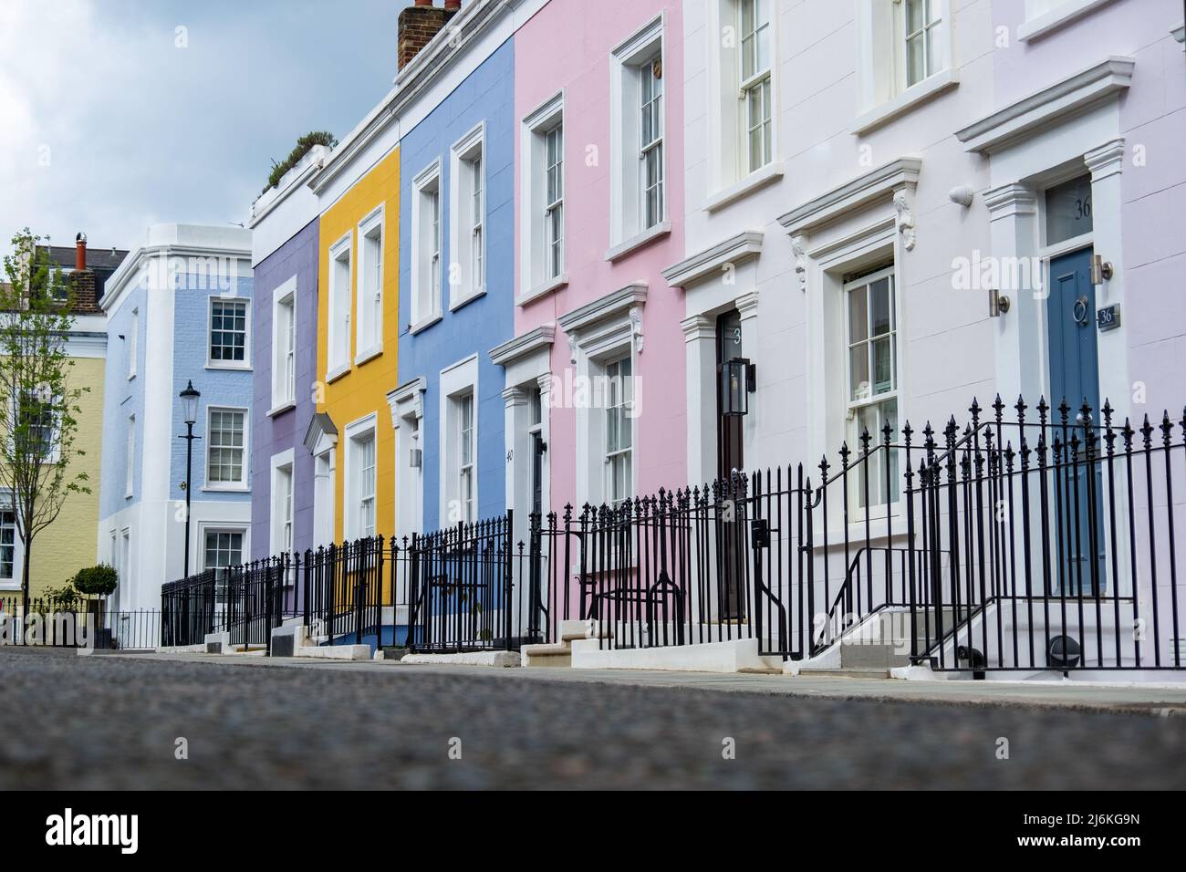 Londra -Aprile 2022: Strada colorata di case cittadine di lusso nella zona di Notting Hill nella zona ovest di Londra Foto Stock
