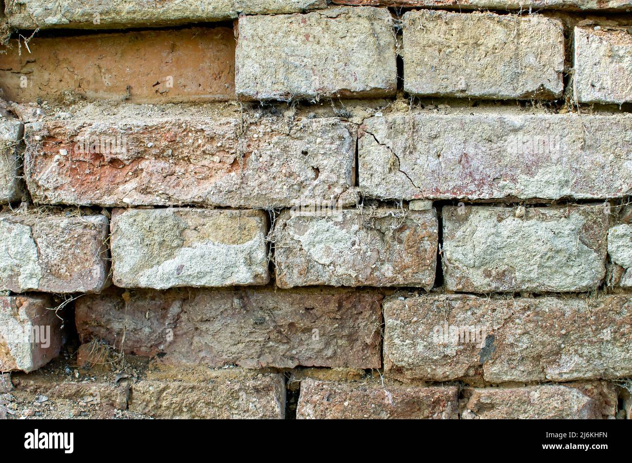 tessitura di un vecchio muro, un muro di mattoni colorati danneggiati, con difetti di intonaco, cobbwes, sfondo, carta da parati per progetti Foto Stock