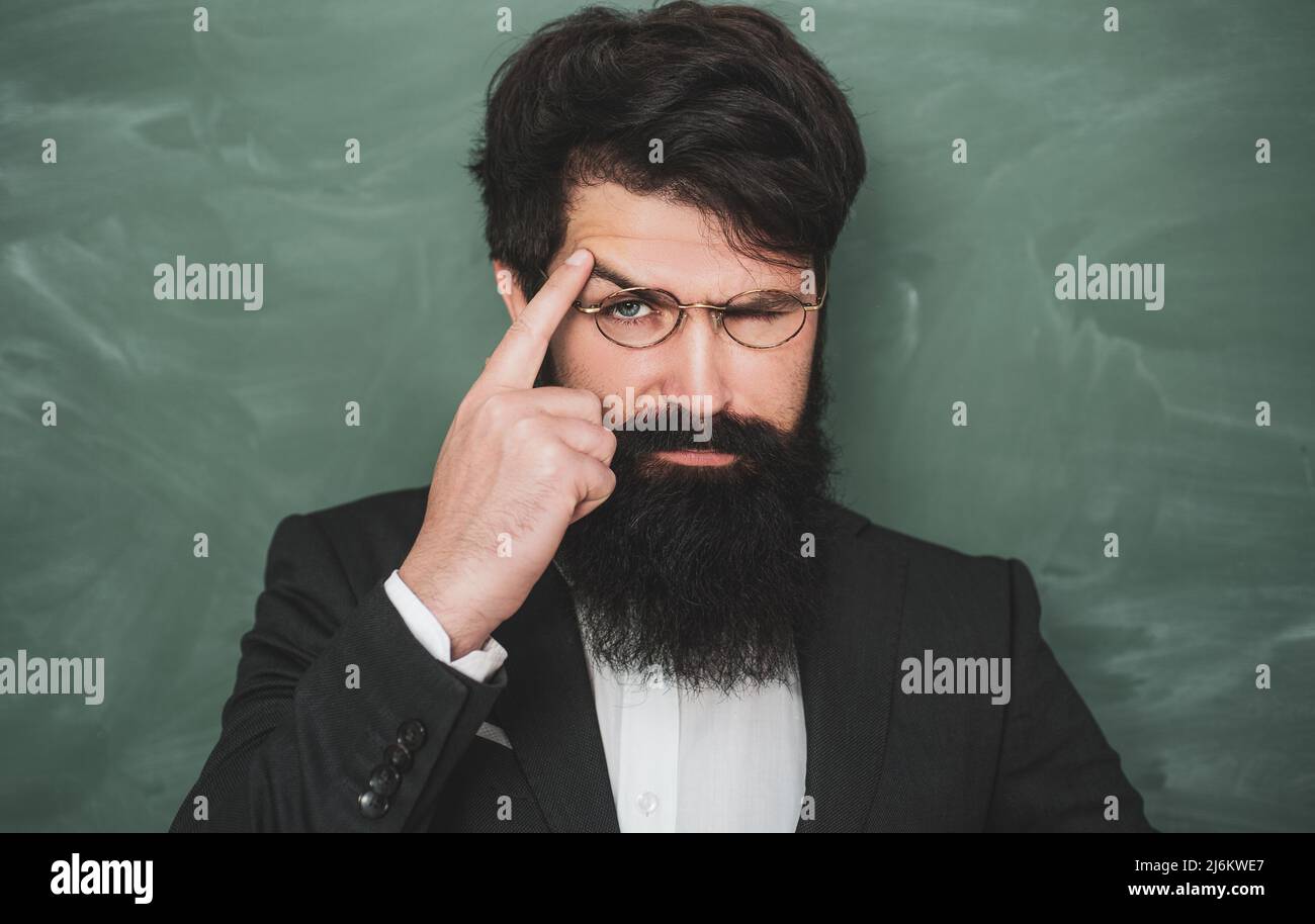 Ritorno a scuola e happy time. Ritratto di professore bearded alla lezione di scuola alle scrivanie in aula - primo piano. Foto Stock