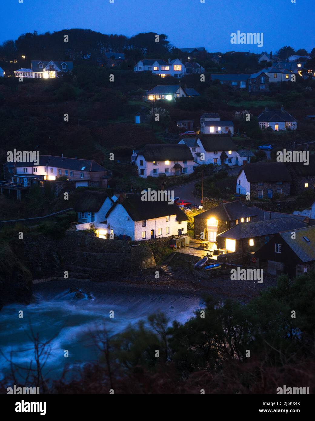 Vista della città di Cadgwith Cove, Cornovaglia, Inghilterra, presa al tramonto Foto Stock