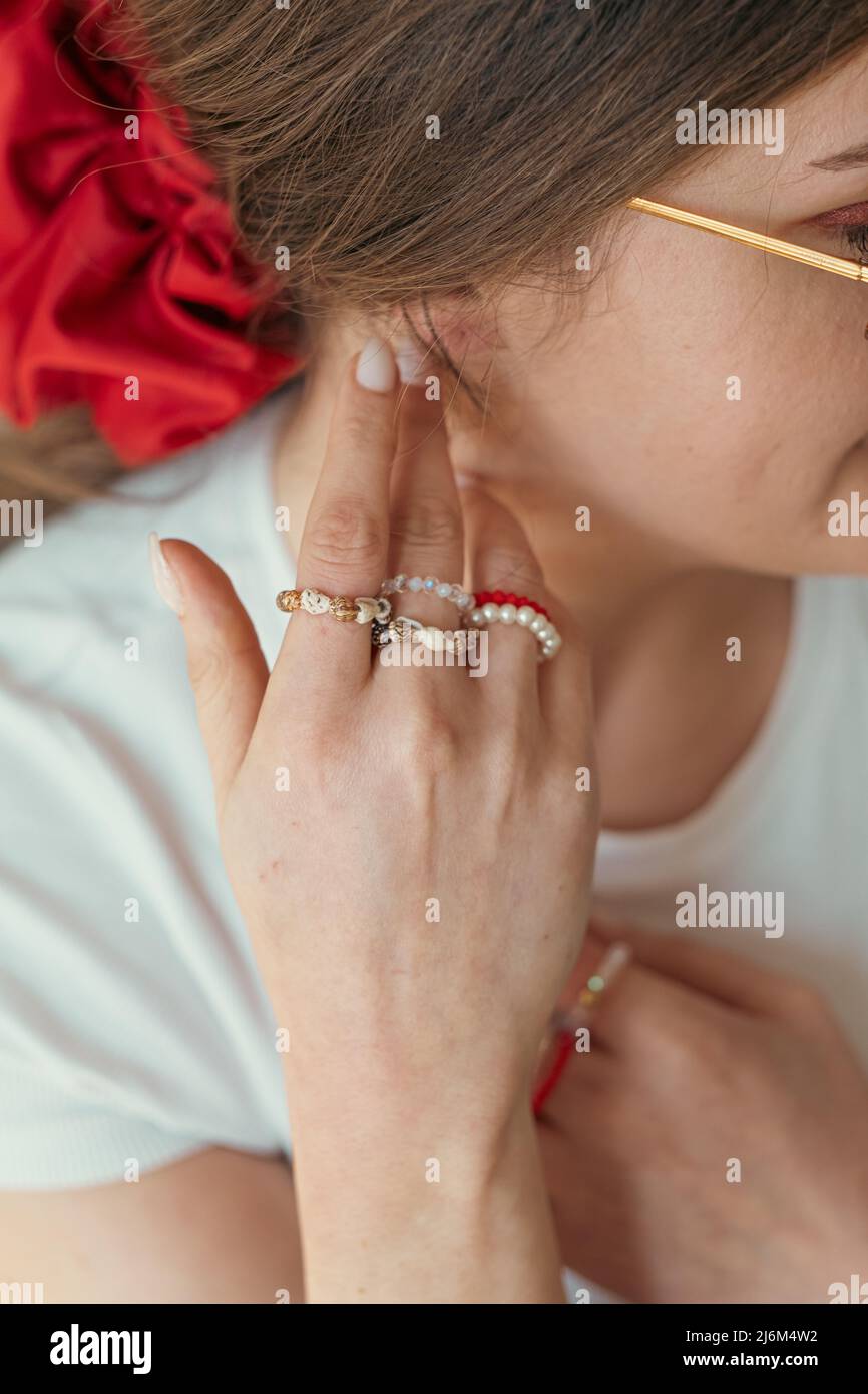 Primo piano ritratto di giovane donna con gioielli dita anelli Foto Stock