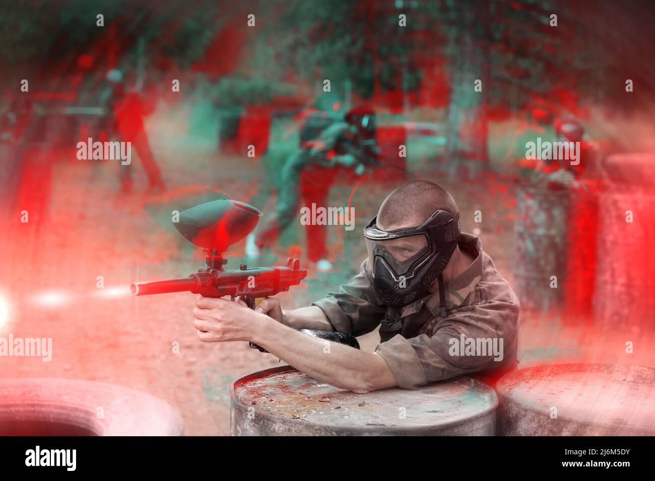 Ritratto dell'uomo in full-gear che gioca a paintball sul campo di battaglia all'aperto Foto Stock