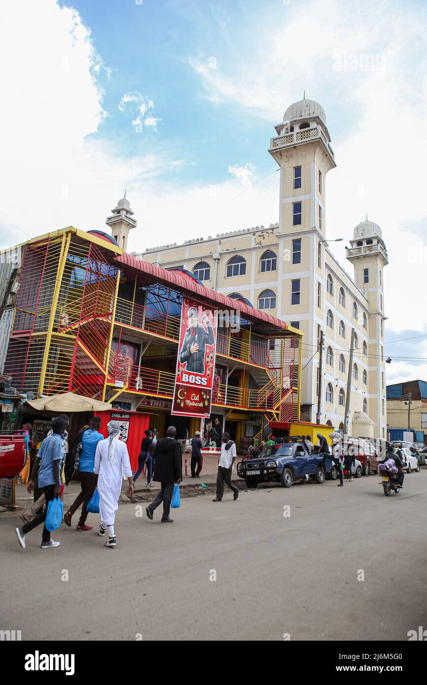 Kenyans camminano oltre un grande banner con il ritratto del direttore di Liverpool Jürgen Klopp che desidera mussulmani un felice Eid al complesso di shopping Anfield lungo la strada di Digo a Majengo. I musulmani in Kenya celebrano Eid-UL-Fitr che segna la fine del mese Santo del Ramadhan. Foto Stock
