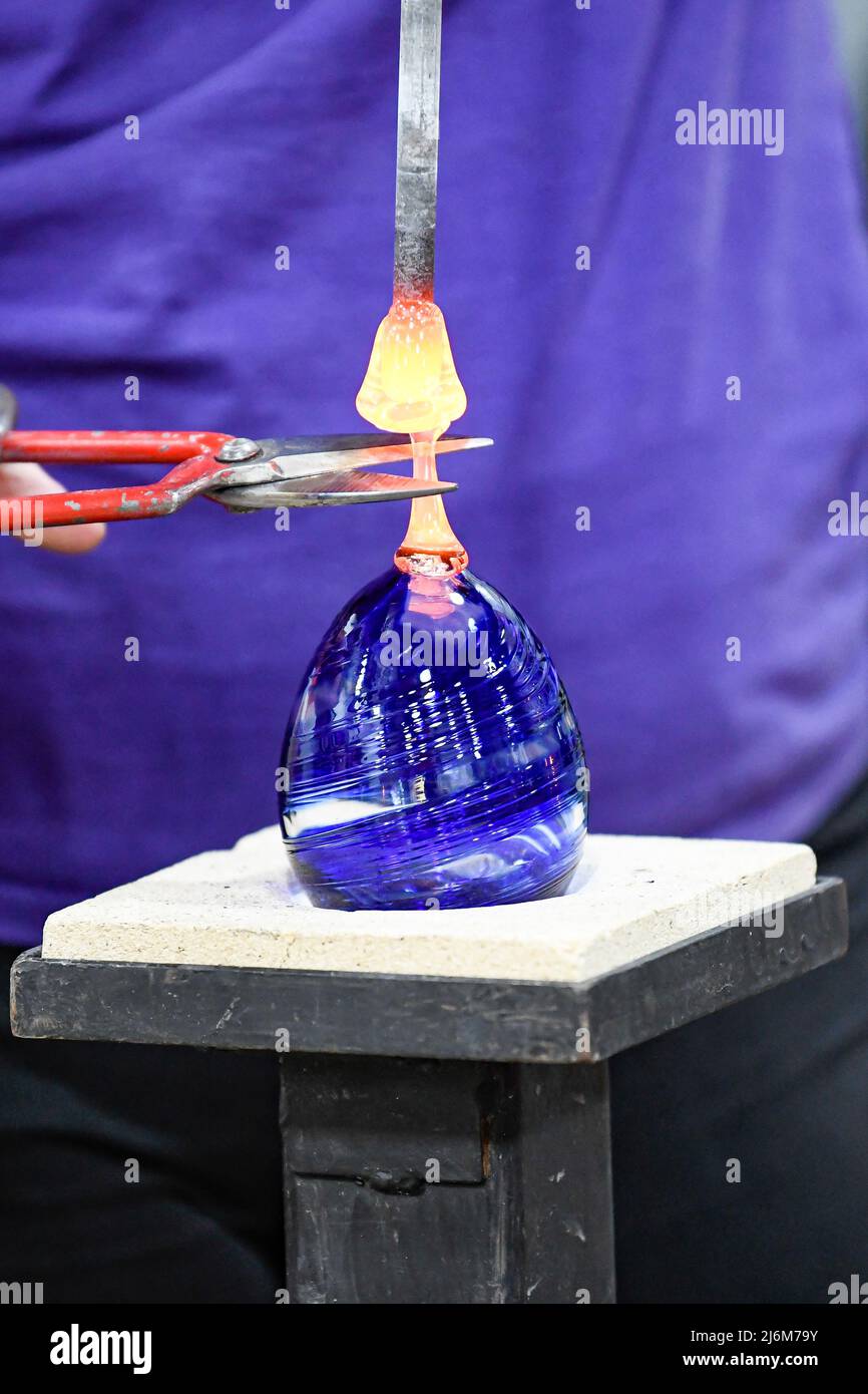 Il vetro fuso viene trasformato in un ornamento al punto di fusione soffiatura del vetro / arte del vetro al Corning Museum of Glass Foto Stock
