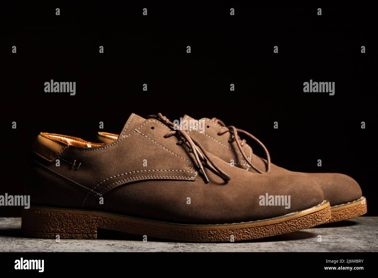 Vista laterale di scarpe marroni con lacci su sfondo nero. Foto Stock