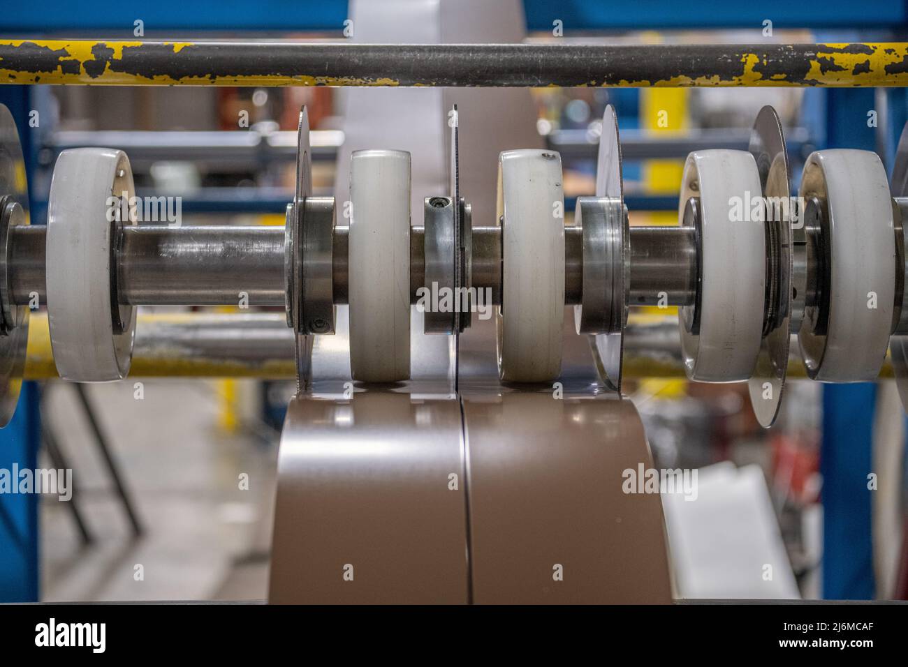 Taglio a macchina dell'acciaio in strisce sul pavimento della fabbrica di tetti in metallo Foto Stock