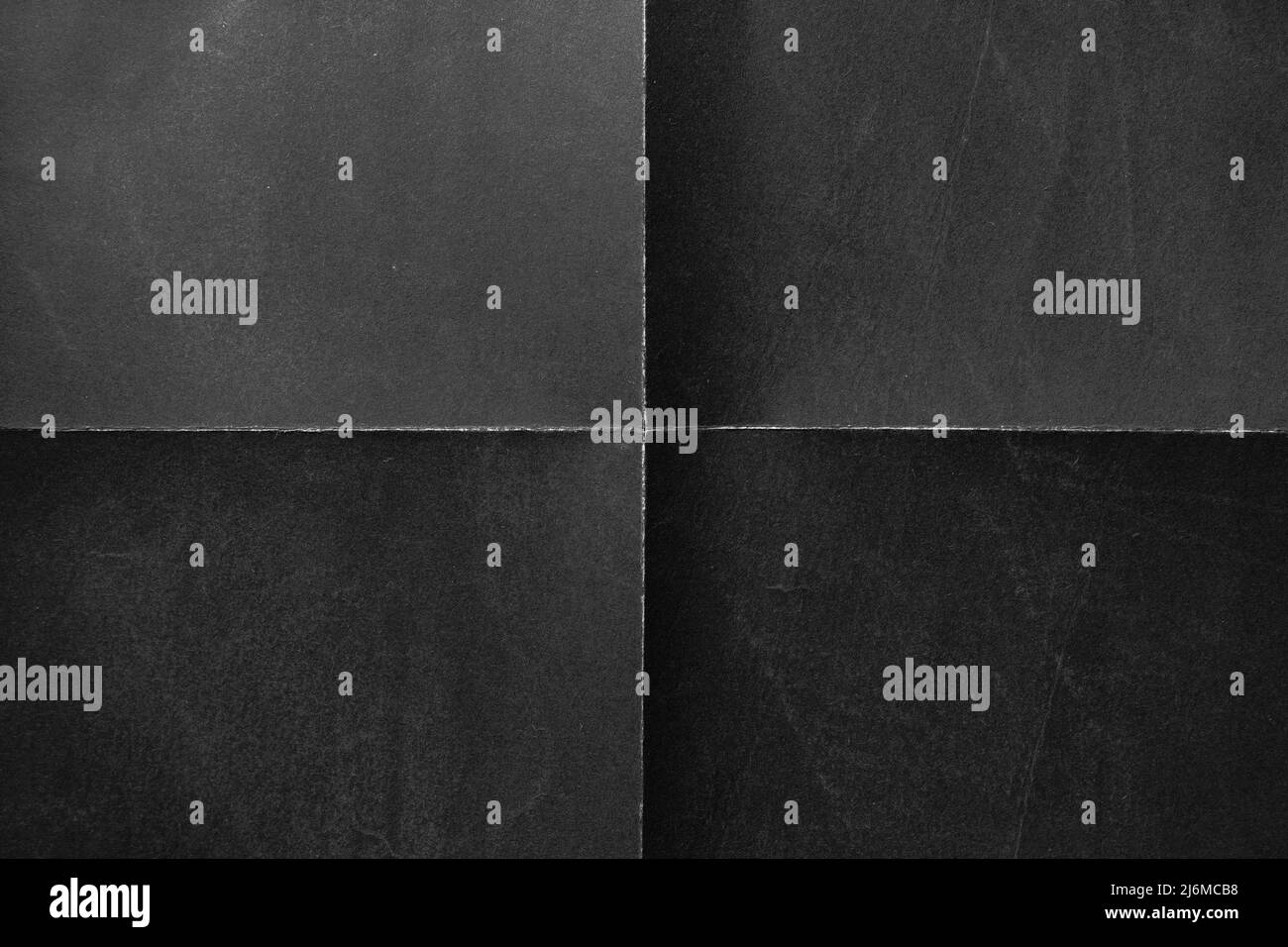 Sfondo nero con pieghe che separano la carta simmetricamente in quattro parti Foto Stock