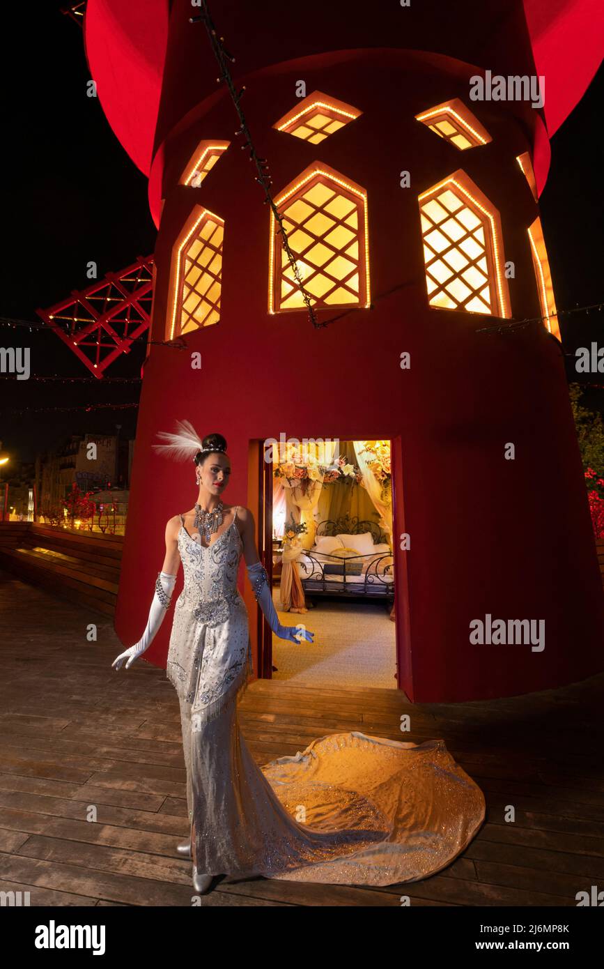 La ballerina Claudine si pone fuori dal mulino a vento del Moulin Rouge il  2 maggio 2022 a Parigi, Francia. Progettata per trasportare gli ospiti  indietro nel tempo fino alla fine del