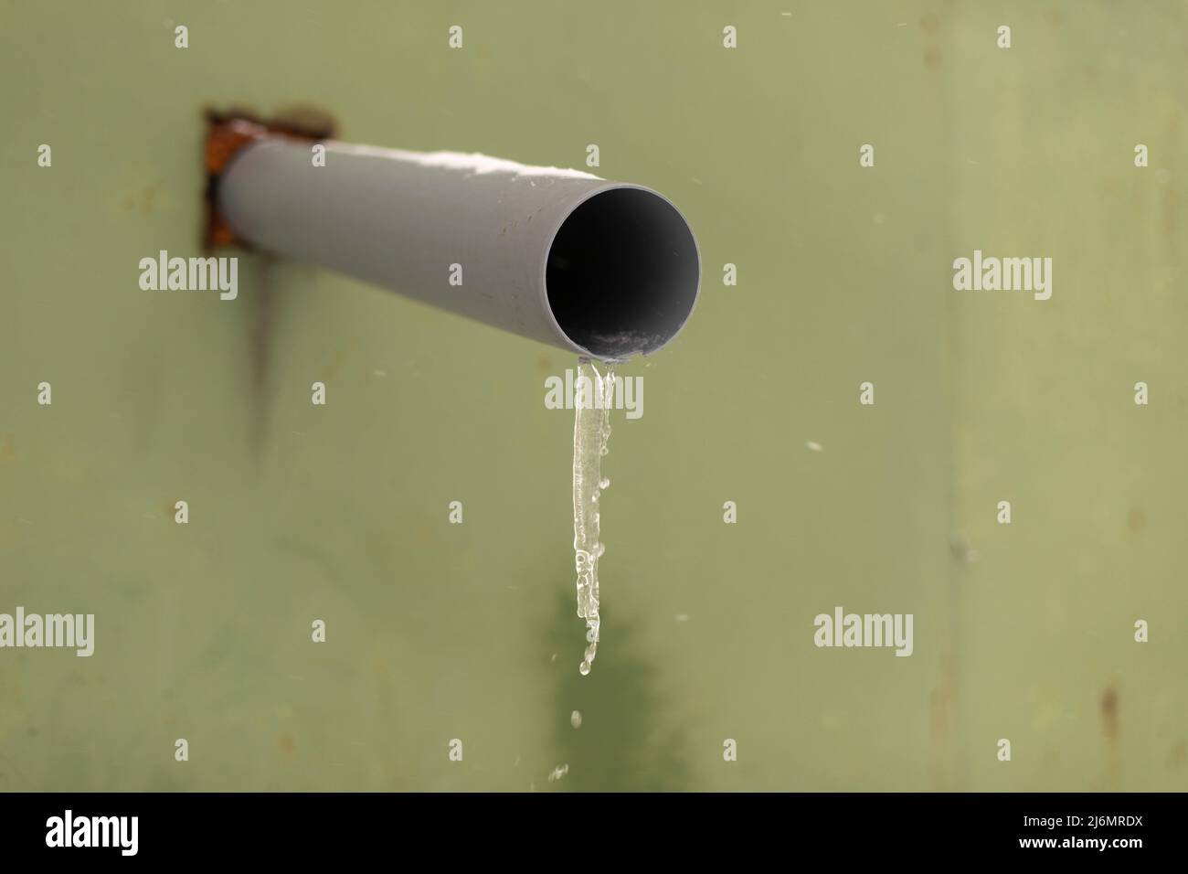 Tubo nel muro. Il tubo di plastica esce dalla parete per scaricare l'acqua. Acqua congelata nelle fogne. Drenaggio temporale. Foto Stock