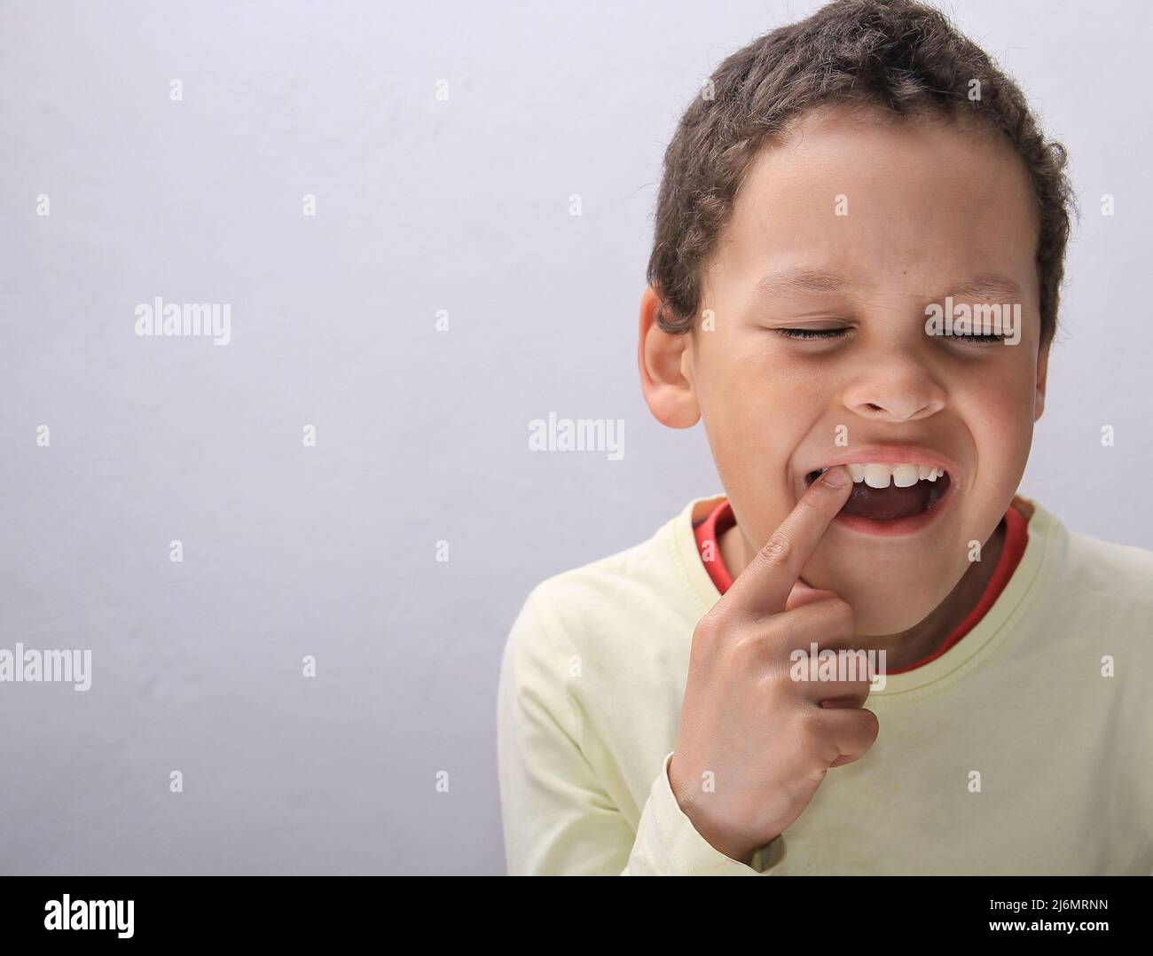 bambino con mal di denti in dolore su sfondo bianco Foto Stock