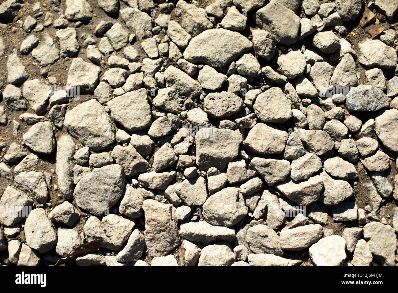 Piccola pietra su strada. Un sacco di pietre. Texture di strada vecchia. Foto Stock