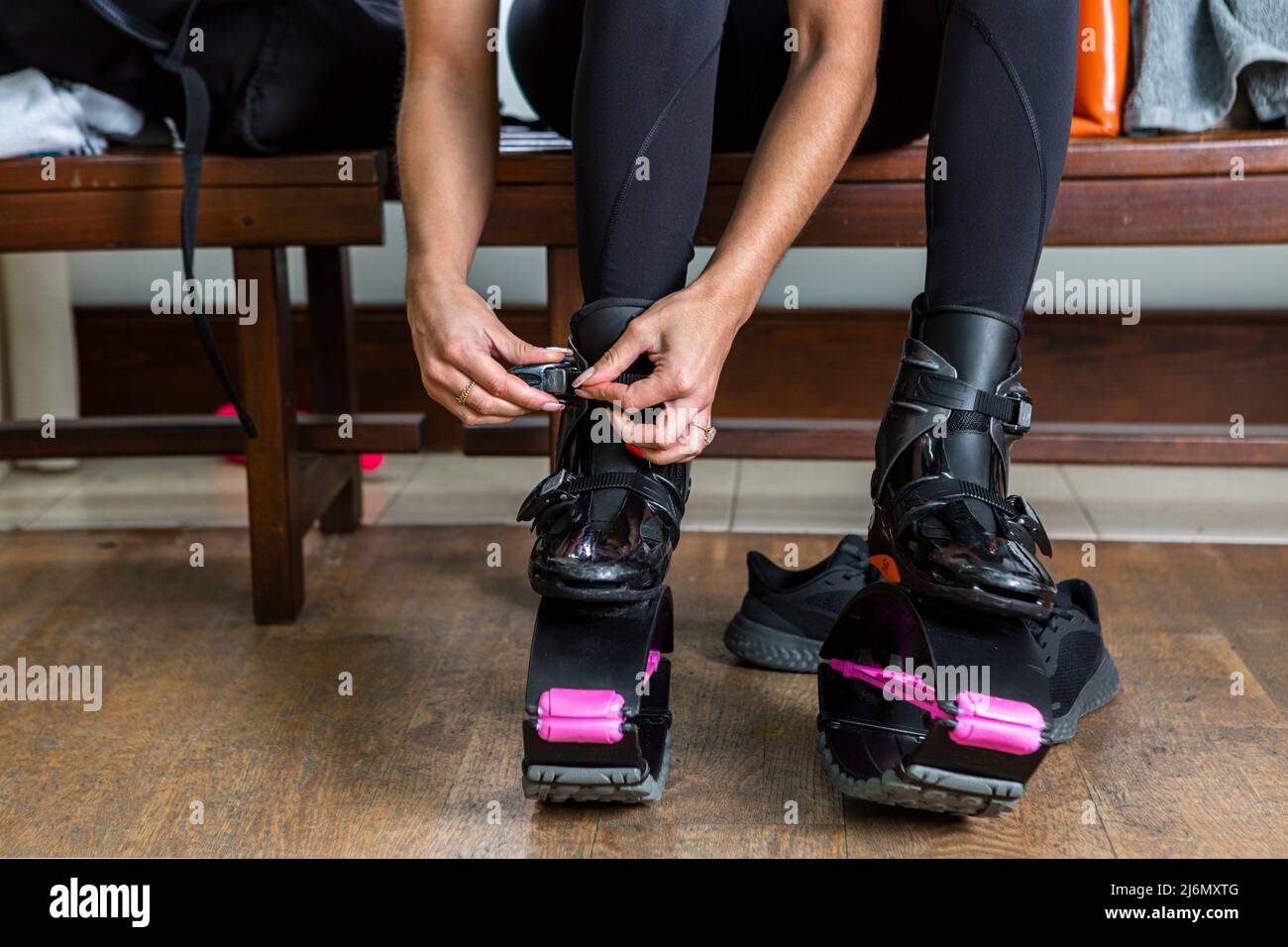 Allacciatura femminile irriconoscibile delle fibbie sulle scarpe da salto  mentre si siede sulla panca in spogliatoio e si prepara per l'allenamento  fitness in palestra Foto stock - Alamy