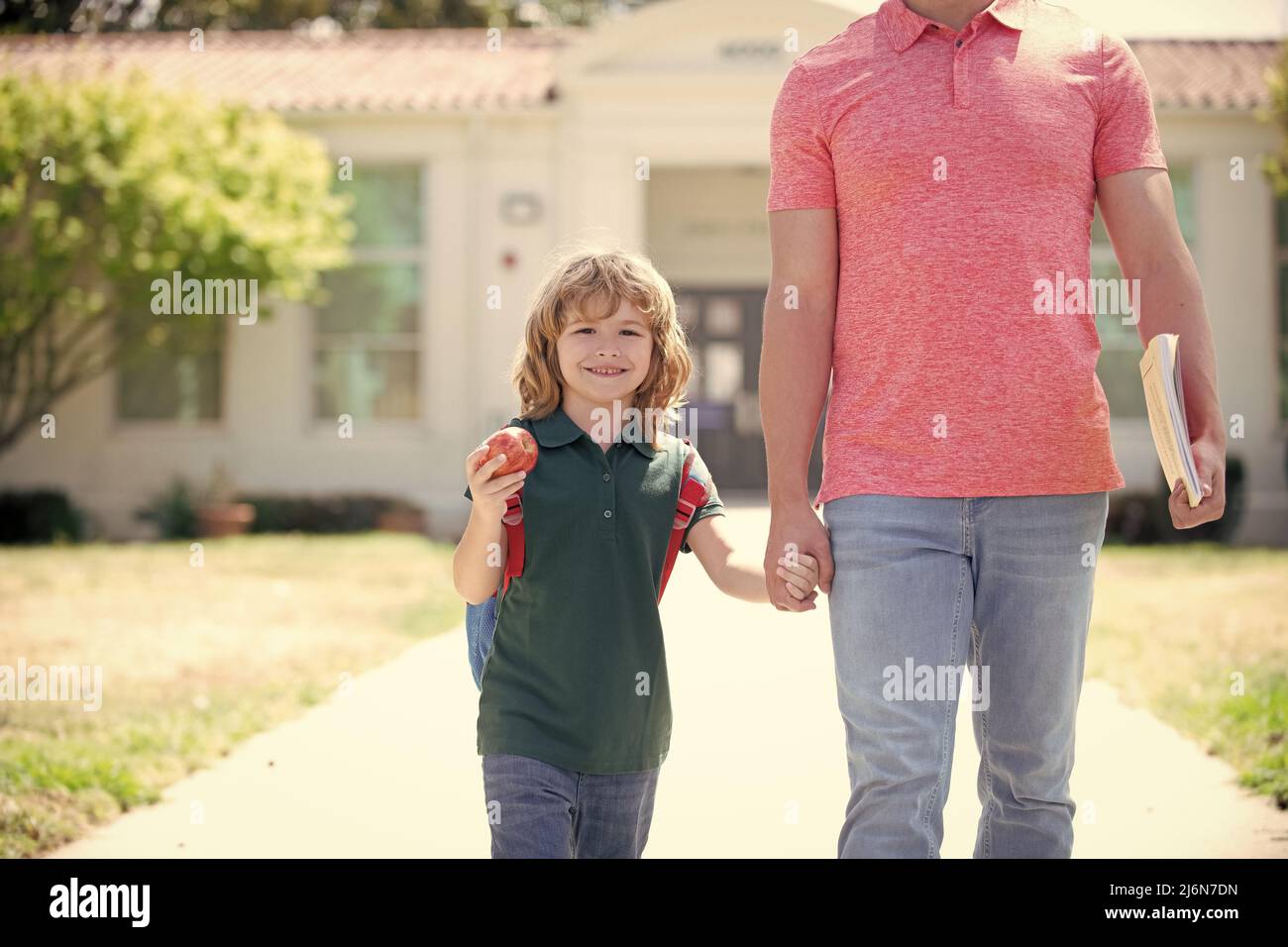 infanzia e paternità. il genitore corto conduce il bambino al primo grado. Foto Stock