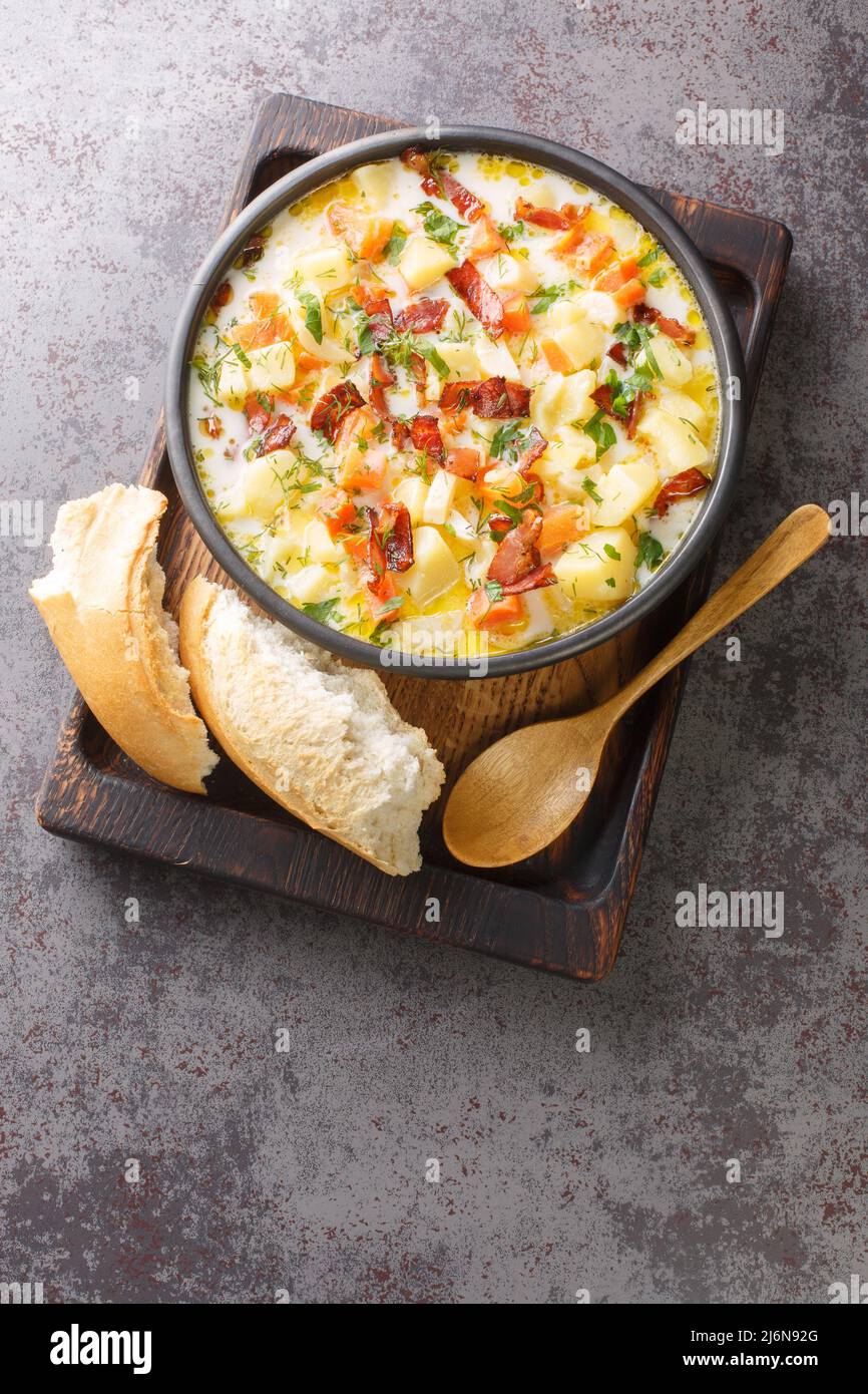 Zuppa di patate polacca con pancetta tradizionale Kartoflanka closeup nel recipiente sul vassoio di legno vista verticale dall'alto Foto Stock