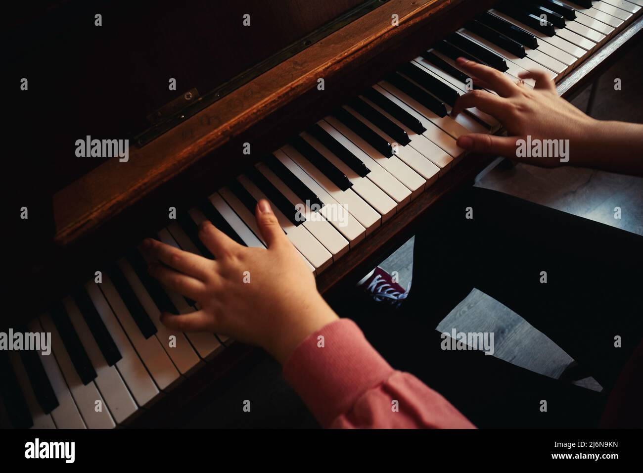La ragazza si sta esercitando a suonare il pianoforte, vista ravvicinata. Foto Stock