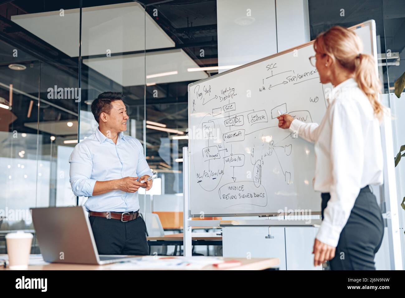 L'uomo e la donna asiatici tossiscono per i dipendenti per migliorare le loro competenze e il lavoro di squadra Foto Stock