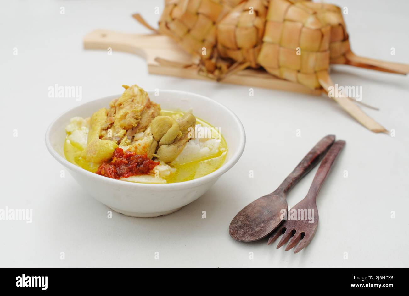 L'Opor Ayam viene servito su sfondo bianco. L'Opor è un tradizionale cibo indonesiano a base di pollo cotto con salsa al latte di cocco Foto Stock