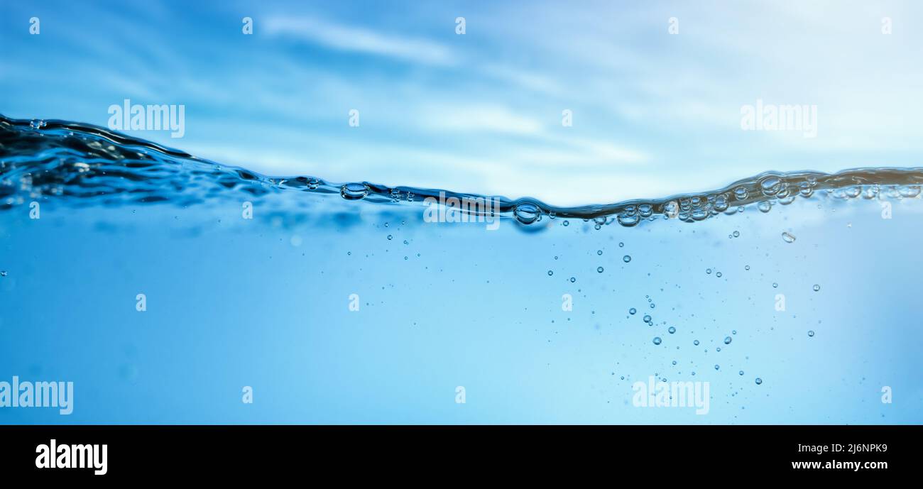 onda d'acqua fresca e limpida con bolle su sfondo cielo blu. banner Foto Stock