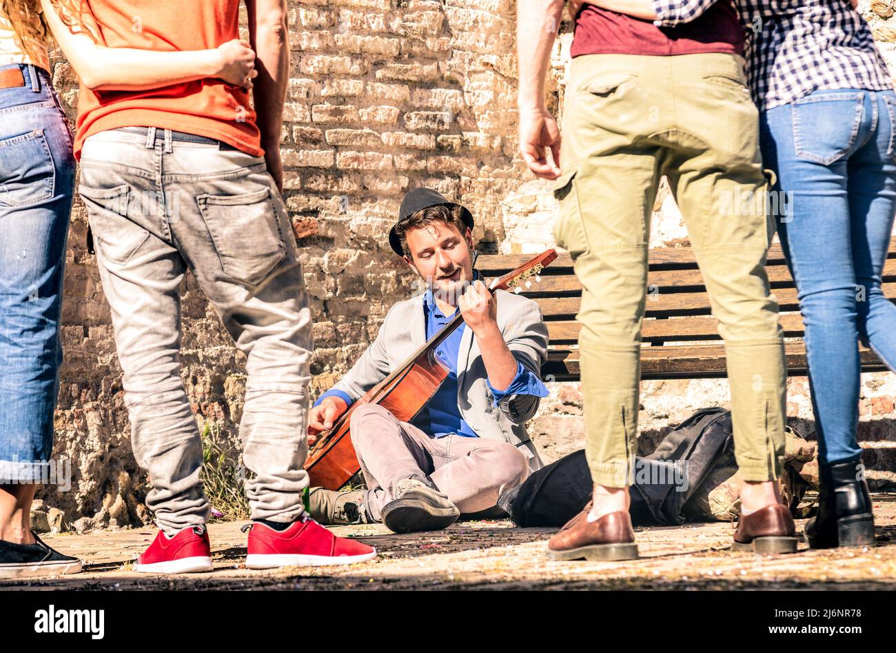 Giovani che guardano artisti di strada che suonano chitarre classiche acustiche all'aperto - concetto di stile di vita di avventura con ragazzo musicista che guadagna soldi w Foto Stock