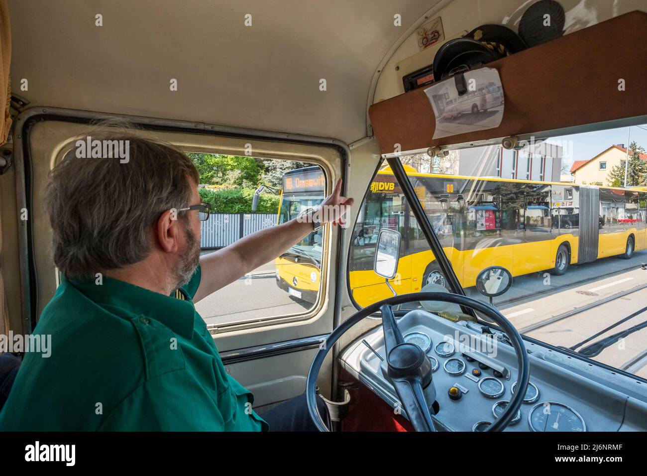 03 maggio 2022, Sassonia, Dresda: L'autista Ronald Günther saluta un collega proveniente dal suo autobus 'Ikarus 66'. L'autobus è stato costruito negli stabilimenti ungheresi di Ikarus nel 1972, ha una potenza di 190 cv ed è stato regolarmente in servizio a Dresda fino al 1985. Un totale di 3 autobus storici della Historische Kraftfahrzeuge des Dresdner Nahverkehrs e. V. sono in viaggio a Dresda questa settimana in occasione del 20th° anniversario dell'associazione. Foto: Matthias Rietschel/dpa-Zentralbild/dpa Foto Stock