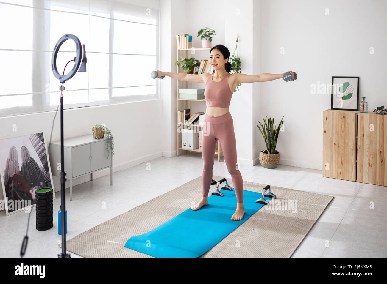 Addestratore femminile professionale che trasmette in streaming una classe di idoneità in linea dalla sede. Foto Stock